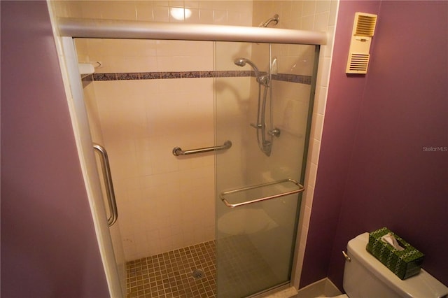 bathroom with toilet and an enclosed shower