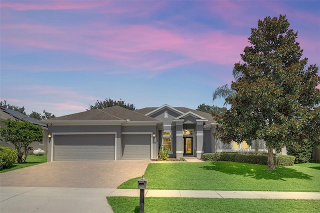 view of front of property featuring a lawn and a garage