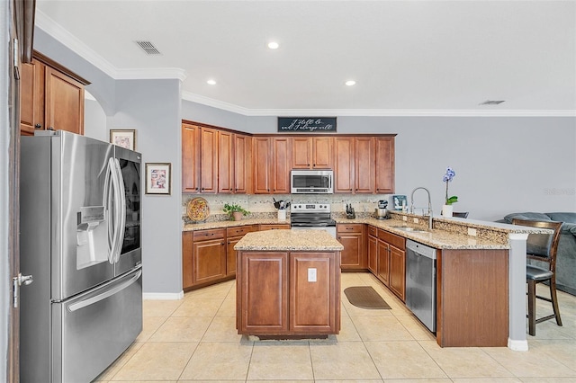 kitchen featuring kitchen peninsula, a kitchen island, a breakfast bar area, stainless steel appliances, and sink