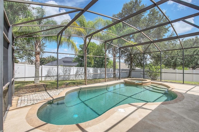 view of pool with glass enclosure, an in ground hot tub, and a patio area