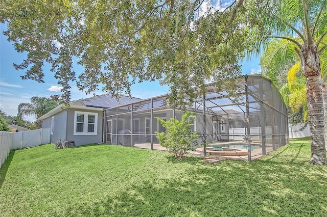 back of house featuring a lanai, a fenced in pool, and a lawn