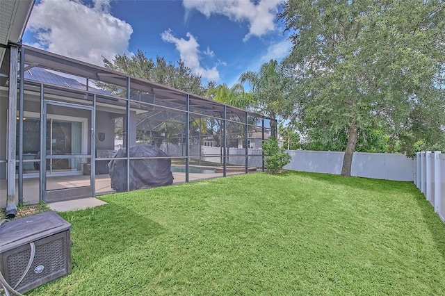 view of yard with a fenced in pool, glass enclosure, and a patio