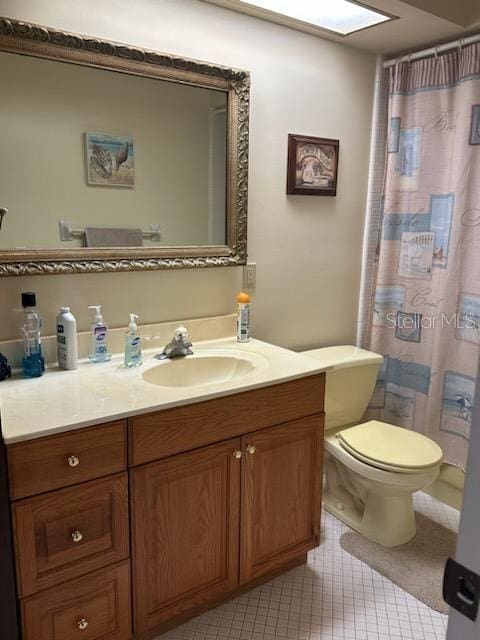 bathroom featuring curtained shower, vanity, a skylight, toilet, and tile patterned floors