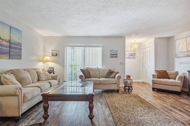 living room featuring an inviting chandelier, a textured ceiling, and hardwood / wood-style floors