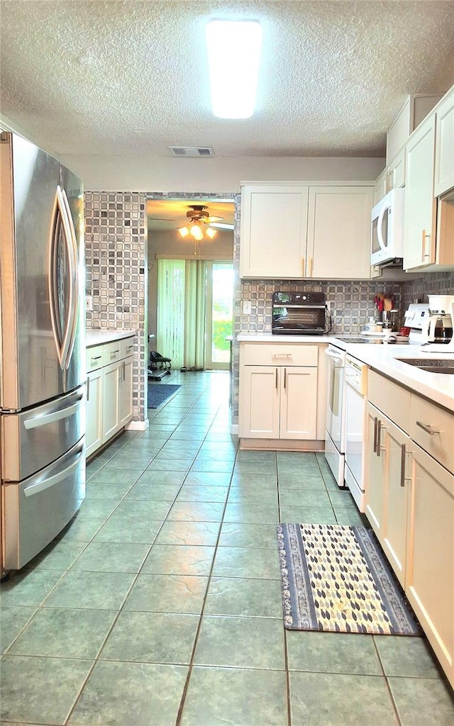 kitchen with white appliances, light tile patterned floors, and backsplash