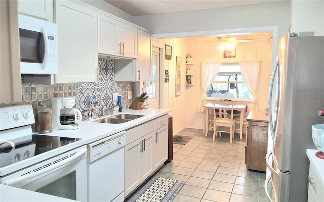 kitchen featuring sink, white cabinetry, white appliances, backsplash, and light tile patterned floors