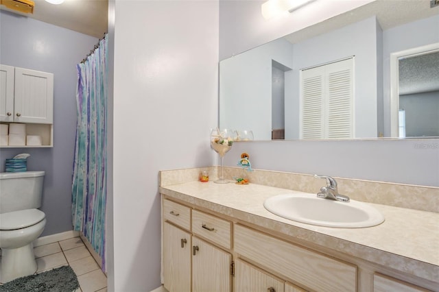 bathroom with tile patterned flooring, vanity, and toilet