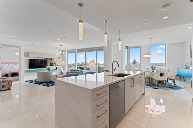 kitchen with a healthy amount of sunlight, sink, an island with sink, and white cabinets