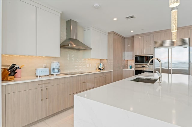 kitchen with sink, wall chimney range hood, decorative backsplash, black appliances, and light brown cabinets