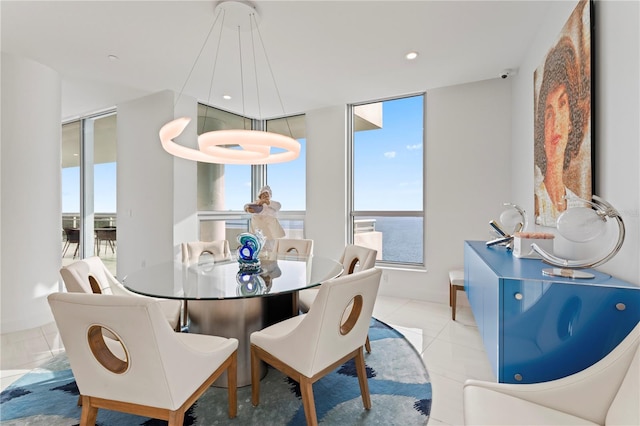 dining room with a water view and light tile patterned floors