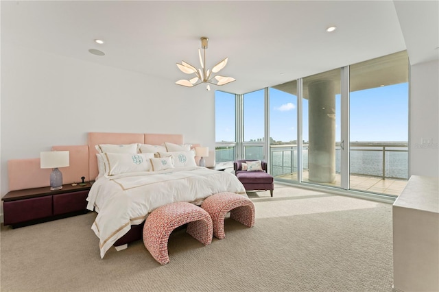 carpeted bedroom featuring a notable chandelier, a water view, a wall of windows, and access to outside