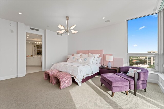 carpeted bedroom with an inviting chandelier and ensuite bathroom