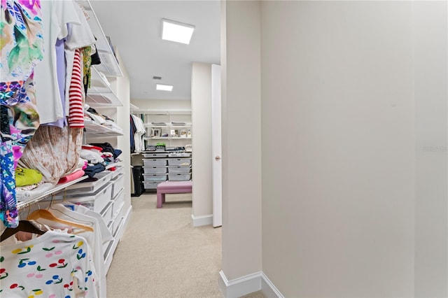 walk in closet with light carpet