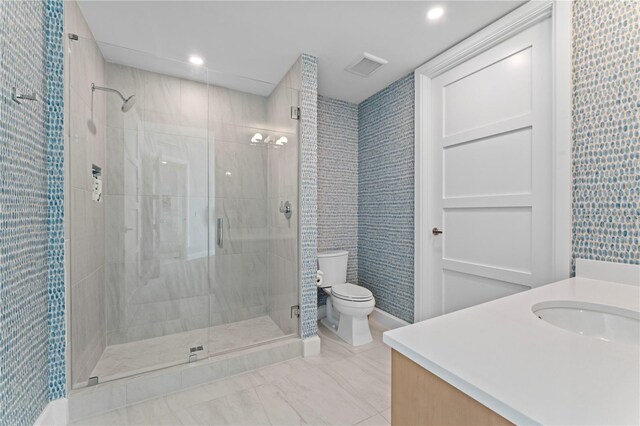 bathroom featuring vanity, a shower with shower door, and toilet