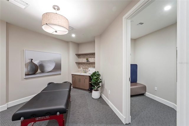 exercise room featuring baseboards, visible vents, carpet, and a sink