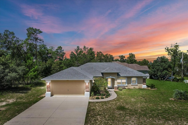 prairie-style home featuring a lawn and a garage