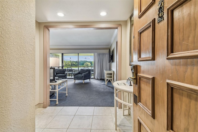 hallway featuring ornamental molding and light colored carpet