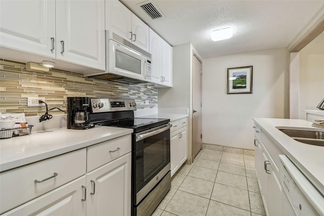 36750 US Highway 19 N Unit 04308, Palm Harbor, FL 34684 - kitchen with visible vents, tasteful backsplash, a textured ceiling, and white appliances