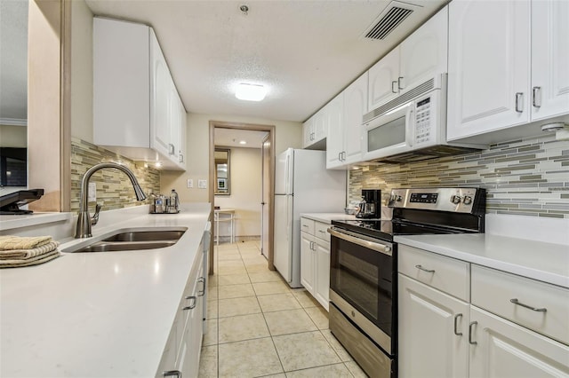 36750 US Highway 19 N Unit 04308, Palm Harbor, FL 34684 - kitchen with white cabinets, light countertops, visible vents, a sink, and white appliances