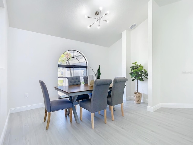 dining room with a notable chandelier and light wood-type flooring