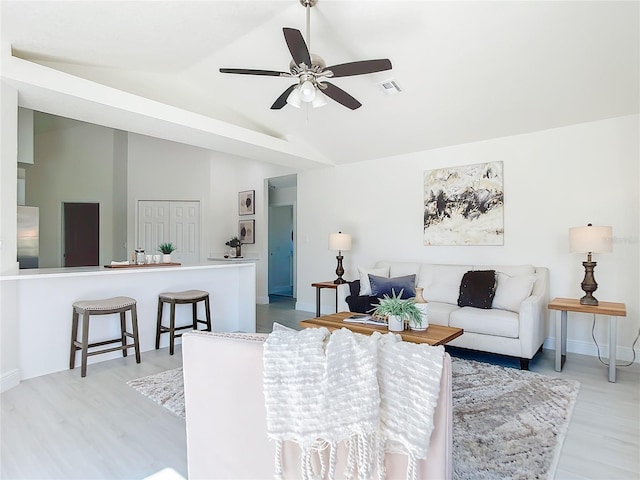 living room featuring ceiling fan, wood-type flooring, and lofted ceiling