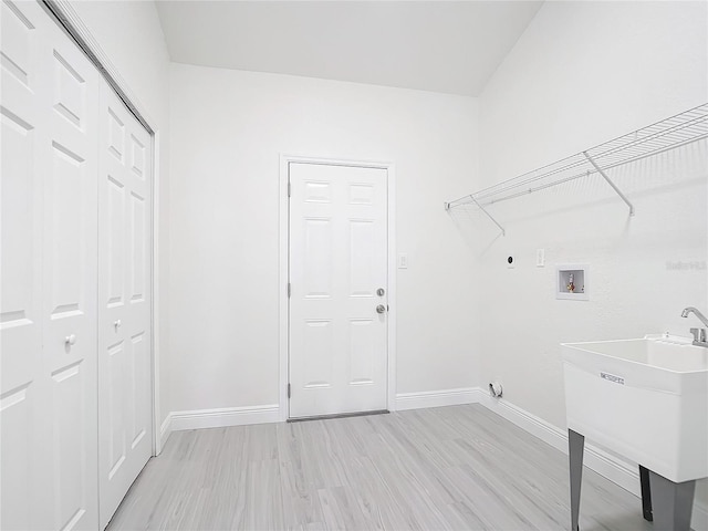 laundry room with hookup for a washing machine, sink, light wood-type flooring, and electric dryer hookup