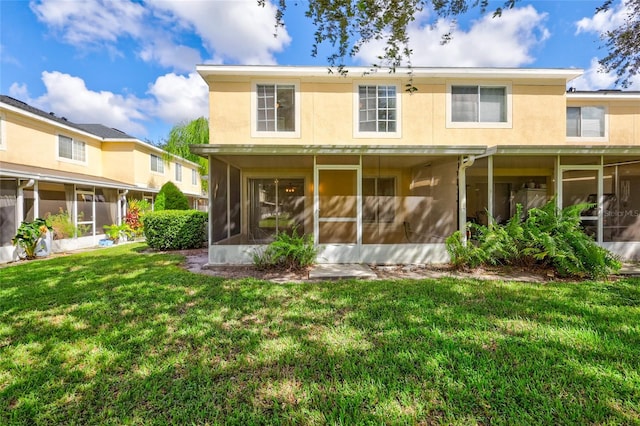 back of property featuring a lawn and a sunroom