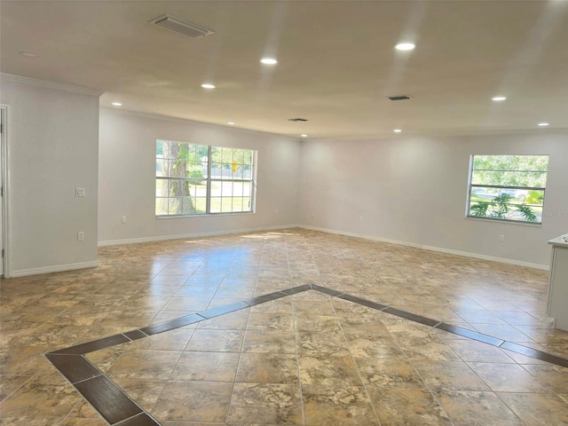 empty room featuring ornamental molding and a wealth of natural light