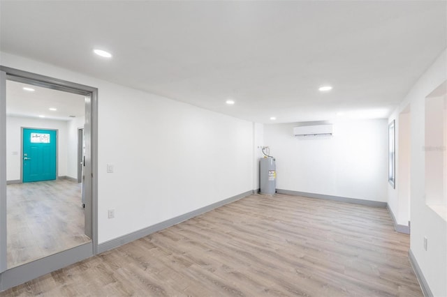 interior space featuring light hardwood / wood-style flooring, electric water heater, and a wall mounted air conditioner