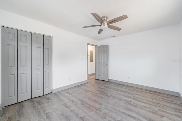 unfurnished bedroom with light hardwood / wood-style flooring, a closet, and ceiling fan