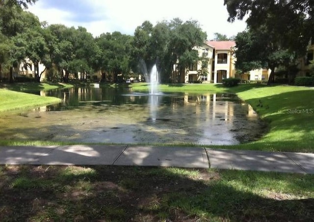 view of home's community with a lawn and a water view