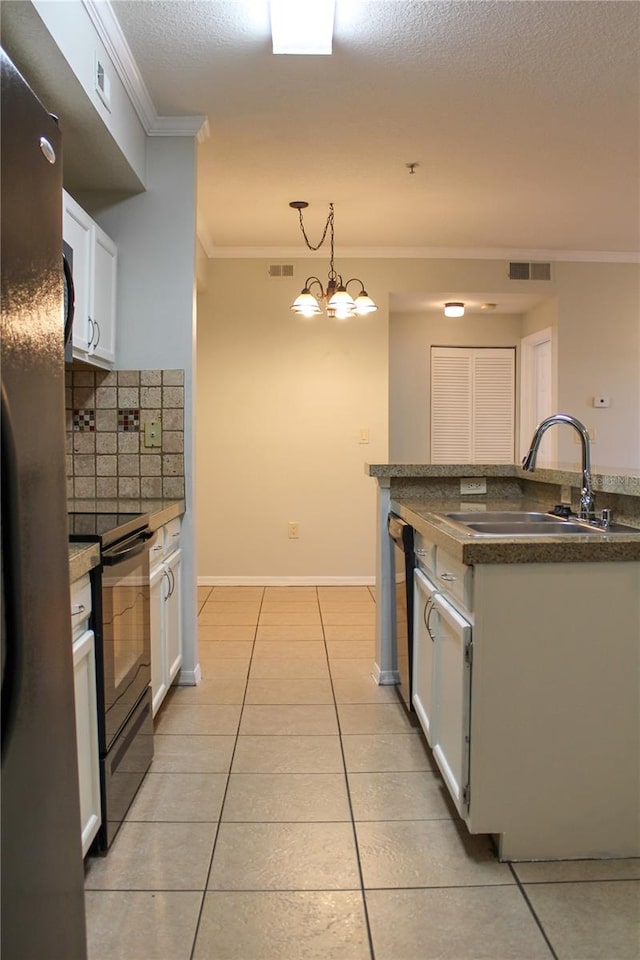 kitchen featuring an inviting chandelier, sink, stainless steel fridge, black range with electric cooktop, and white cabinetry