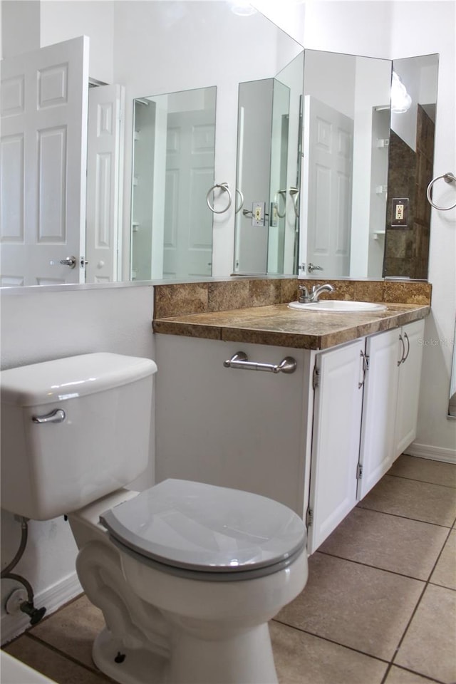 bathroom with tile patterned flooring, vanity, and toilet