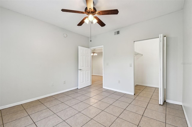 5608 Pinnacle Heights Cir Unit 305, Tampa, FL 33624 - unfurnished bedroom featuring baseboards, light tile patterned floors, a walk in closet, ceiling fan, and a closet