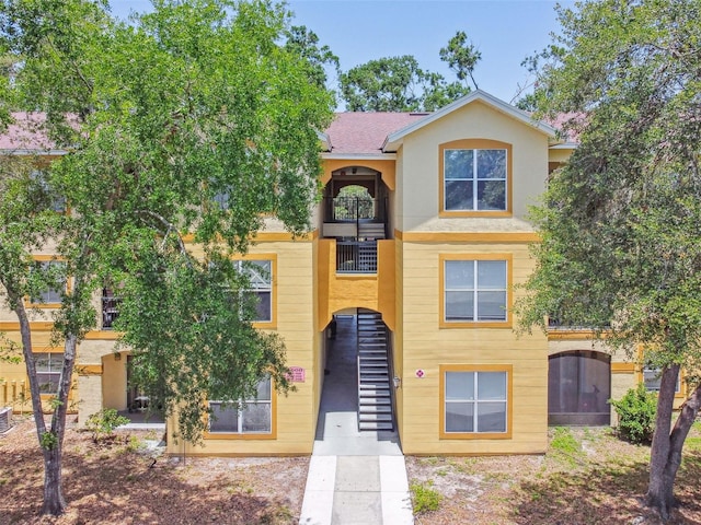 5608 Pinnacle Heights Cir Unit 305, Tampa, FL 33624 - view of property with a balcony, stucco siding, stairway, and cooling unit