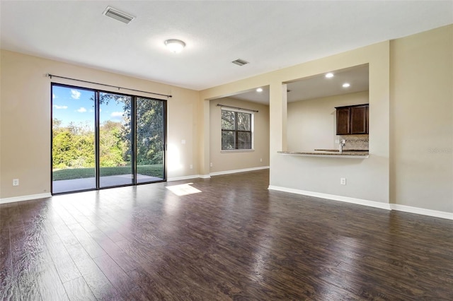 unfurnished living room featuring dark hardwood / wood-style flooring and sink