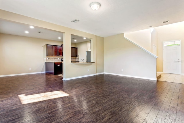 unfurnished living room with dark hardwood / wood-style flooring