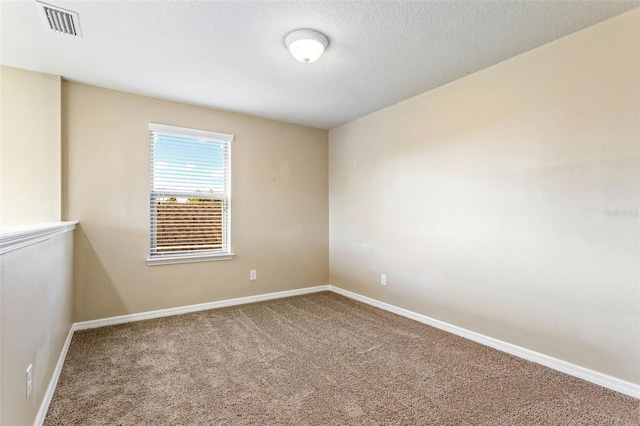 carpeted empty room with a textured ceiling