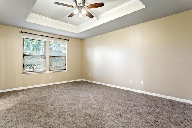 unfurnished room with ornamental molding, carpet, a tray ceiling, and ceiling fan