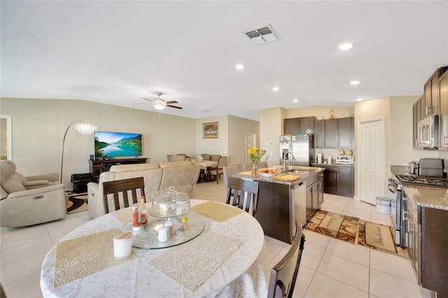 tiled dining area with ceiling fan and sink