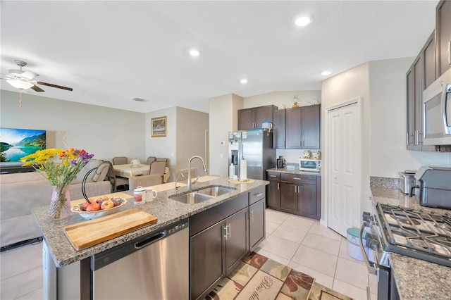 kitchen featuring sink, an island with sink, appliances with stainless steel finishes, light tile patterned floors, and ceiling fan