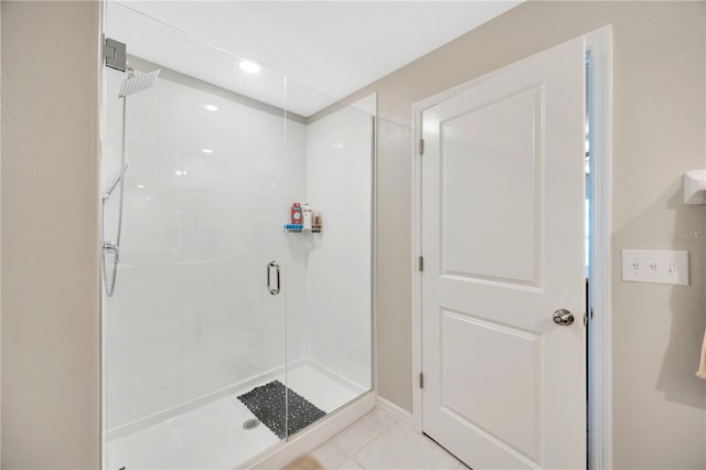 bathroom featuring a shower with shower door and tile patterned flooring