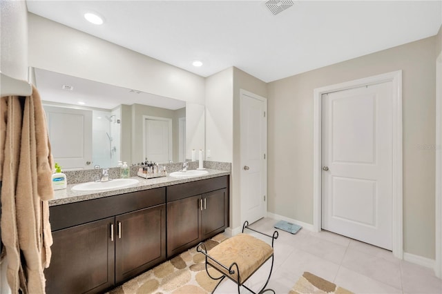 bathroom featuring tile patterned floors, a shower with shower door, and vanity