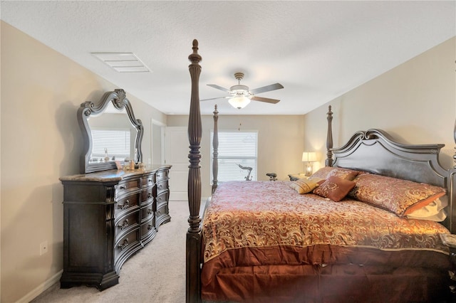 carpeted bedroom featuring ceiling fan and a textured ceiling