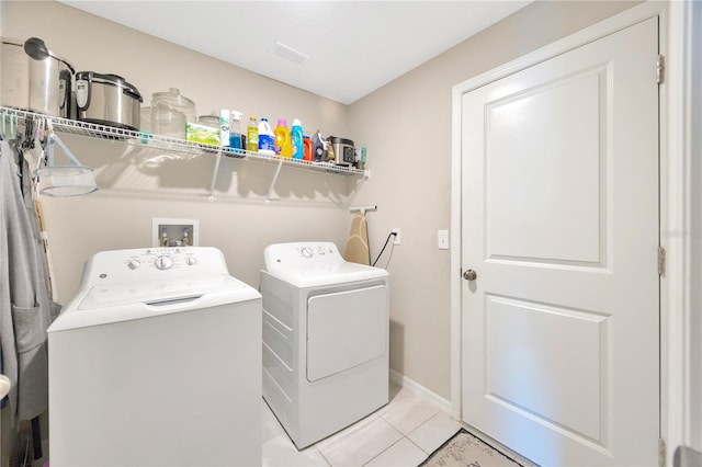 laundry area with light tile patterned floors and washing machine and clothes dryer