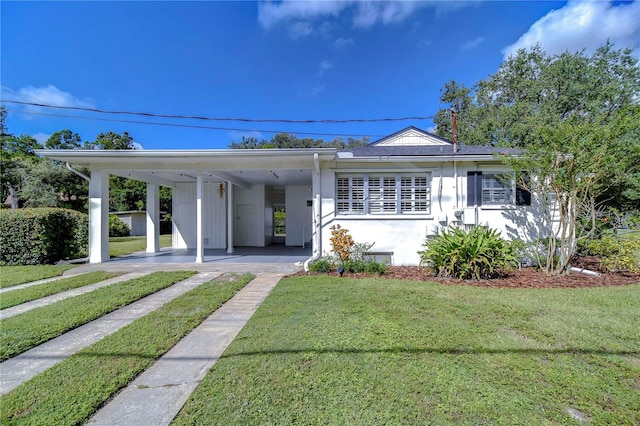 view of front of property with a front lawn and a carport