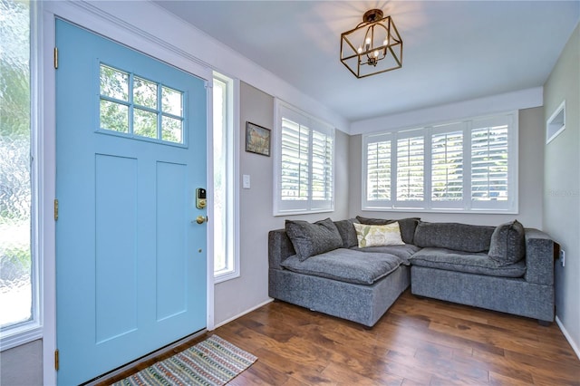 foyer with a notable chandelier and dark wood-type flooring