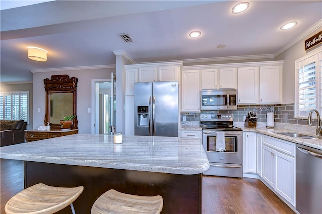 kitchen featuring light stone counters, stainless steel appliances, dark hardwood / wood-style floors, and white cabinetry