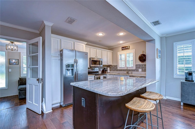 kitchen with appliances with stainless steel finishes, decorative backsplash, white cabinetry, and dark hardwood / wood-style floors