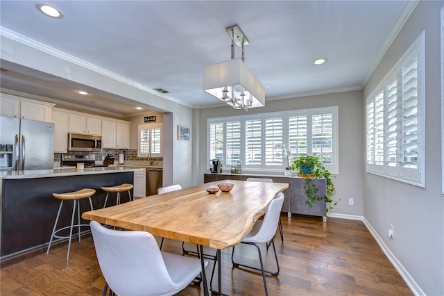 dining area with a healthy amount of sunlight, crown molding, an inviting chandelier, and dark wood-type flooring